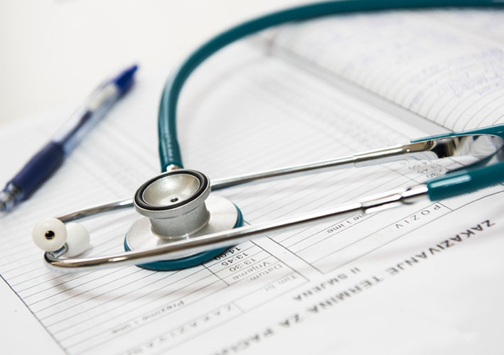 Photo of documents with pen and stethoscope laying on top of them