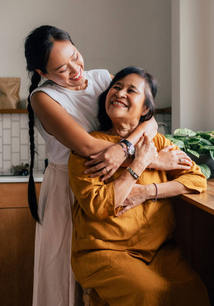 Photo of young woman hugging grandmother